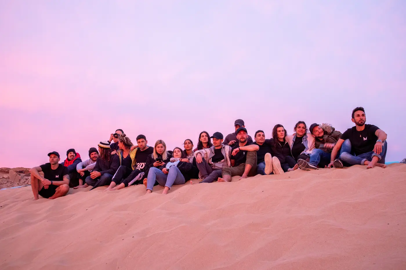 Team seduto sulle dune durante un momento di retreat